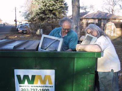 photo of programmers pulling monitor and keyboard out of dumpster